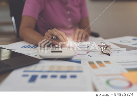 Asian Businesswoman calculating saving account balance with calculator, account and saving concept Asian Businesswoman calculating saving account balance with calculator, account and saving concept 94825874