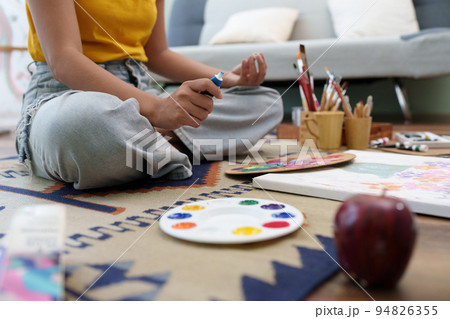 Joyful young female artist painting on canvas at workshop Joyful young female artist painting on canvas at workshop 94826355