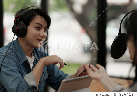 Asian podcaster making audio podcast working with guest at home studio 94826418