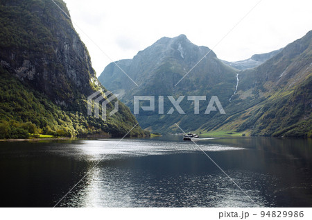 A ship sailing in Norwegian fjords. Amazing nature view with fjord and mountains. Beautiful reflection. 94829986