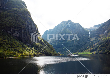 A ship sailing in Norwegian fjords. Amazing nature view with fjord and mountains. Beautiful reflection. 94829987