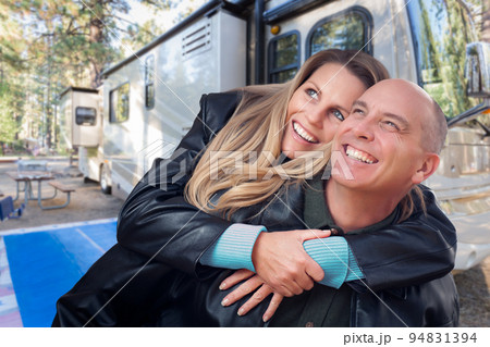 Happy Caucasian Couple In Front of Their Beautiful RV At The Campground. 94831394