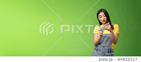 Carefree geeky cute asian brunette waste time university campus, playing online smartphone game, look amused entertained telephone screen, tilting body move character, open mouth excited Carefree geeky cute asian brunette waste time university campus, playing online smartphone game, look amused entertained telephone screen, tilting body move character, open mouth excited 94833517