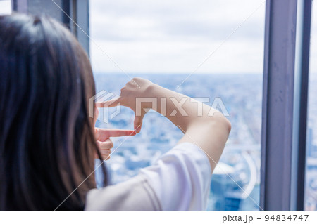 指でフレームを作る少女 94834747
