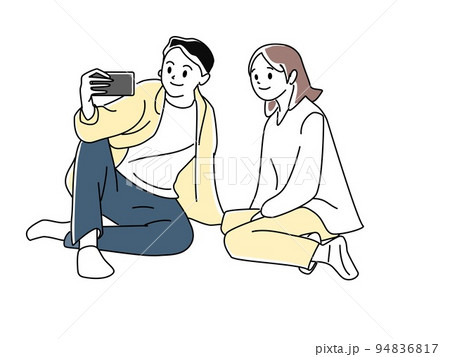 地面に座ってスマホを見ているカップル 94836817