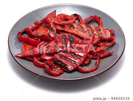 Grilled Slices of red pepper with stripes from a grill in ceramic plate isolated on white background 94838316