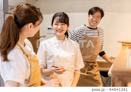 厨房・キッチンで料理を作る調理師とスタッフ 94841381