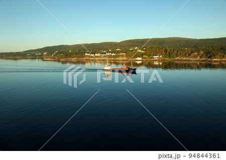 ベルゲン近郊の静寂な海を走る船 94844361