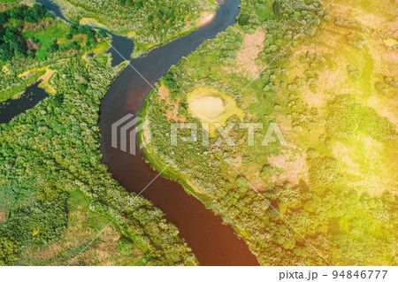 Bird's Eye View Of Green Forest Woods In Sunny Day. Aerial View Of Summer Curved River Landscape. Top View Of Beautiful European Nature From High Attitude. Drone Flight View 94846777