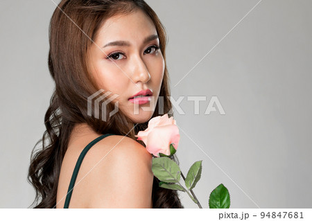 Closeup ardent female model with fair skin and perfect makeup holding flowers. 94847681