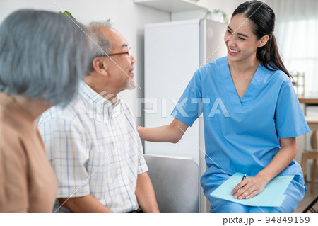 Female doctor visiting and talking to her contented senior couple at their home 94849169