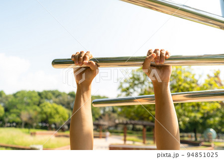 公園の健康遊具で背伸ばしする女性の手 公園の健康遊具で背伸ばしする女性の手 94851025