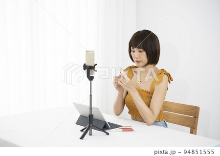 部屋でコスメのライブ配信する女性 94851555