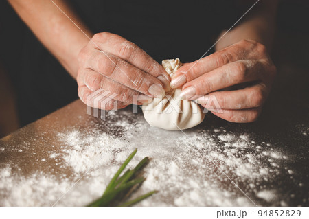 Khinkali cooking process close up. Chef hands sculpt khinkali. 94852829
