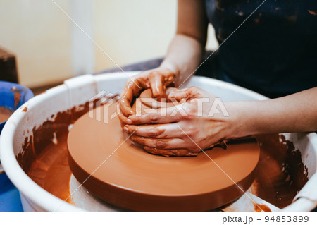 Professional potter works on a pottery wheel.. Professional potter works on a pottery wheel.. 94853899