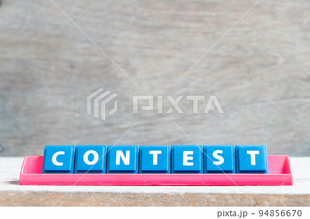 Tile alphabet letter with word contest in red color rack on wood background Tile alphabet letter with word contest in red color rack on wood background 94856670