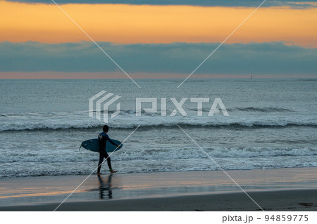 早朝の砂浜を歩くサーファー 早朝の砂浜を歩くサーファー 94859775
