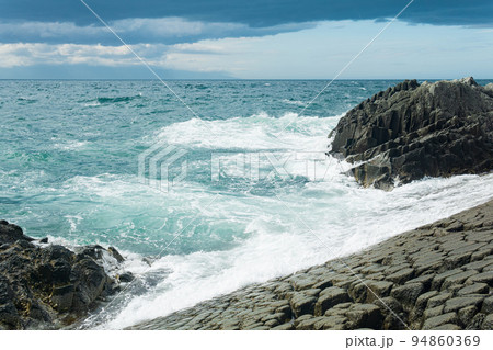rocky seashore formed by columnar basalt against the surf, coastal landscape of the Kuril Islands rocky seashore formed by columnar basalt against the surf, coastal landscape of the Kuril Islands 94860369