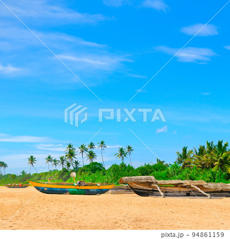 tropical beach with palm trees and fishing boats in Sri Lanka. tropical beach with palm trees and fishing boats in Sri Lanka. 94861159