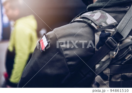Soldier of the Polish army with a camouflage uniform with the Polish flag on his sleeve. Soldier of the Polish army with a camouflage uniform with the Polish flag on his sleeve. 94861510