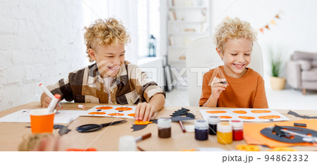 Cute children boys making Halloween home decorations Cute children boys making Halloween home decorations 94862332