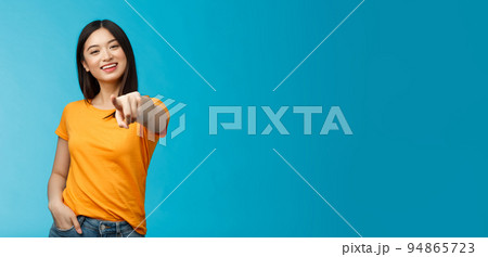Lucky winner. Cheerful charismatic asian cute urban girl stand yellow t-shirt smiling friendly pointing finger camera choosing, picking person, inviting you team, stand happy blue background Lucky winner. Cheerful charismatic asian cute urban girl stand yellow t-shirt smiling friendly pointing finger camera choosing, picking person, inviting you team, stand happy blue background 94865723
