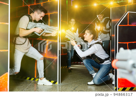 Young people playing laser tag Young people playing laser tag 94866317