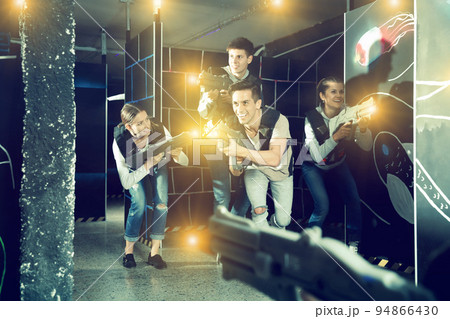 Guy with friends playing laser tag Guy with friends playing laser tag 94866430