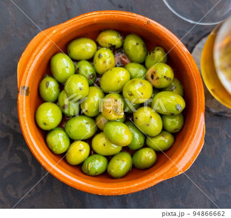 Trickle of pickled green olives on plate Trickle of pickled green olives on plate 94866662