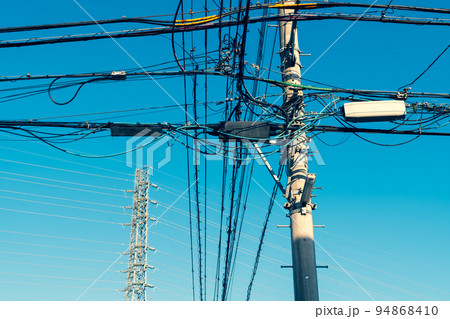 住宅街の入り組む電線と高圧送電線を支える送電鉄塔 b-3 暖色加味 住宅街の入り組む電線と高圧送電線を支える送電鉄塔 b-3 暖色加味 94868410