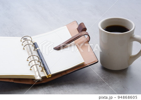 茶色の革のシステム手帳とブラックコーヒー 茶色の革のシステム手帳とブラックコーヒー 94868605