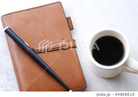 茶色の革のシステム手帳とブラックコーヒー 94868610