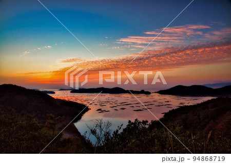 空、海、島が朝日で黄金色に染まる絶景 94868719