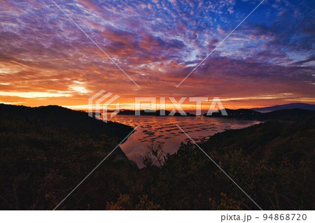 空、海、島が朝日で黄金色に染まる絶景 94868720