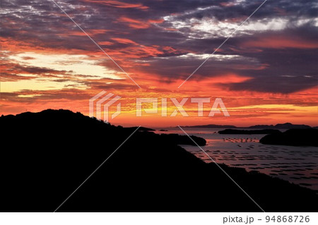 空、海、島が朝日で黄金色に染まる絶景 94868726