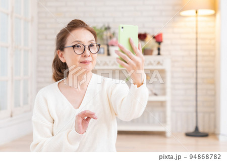 スマートフォンを見るシニア女性 自撮り スマートフォンを見るシニア女性 自撮り 94868782