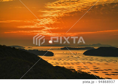 空、海、島が朝日で黄金色に染まる絶景 94868937