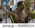 3d game artist works at a computer in the office and eats a big pizza  94869314