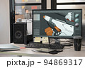 Designer's computer on table with a 3D model of a dog robot on a monitor screen 94869317