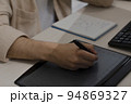 Close-up of the artist's hands of a designer drawing with a stylus on tablet 94869327