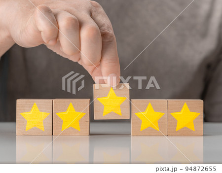 Hand hold wood block cube with five star shape. Best excellent business services rating customer experience concept. best excellent business services rating customer experience concept 94872655