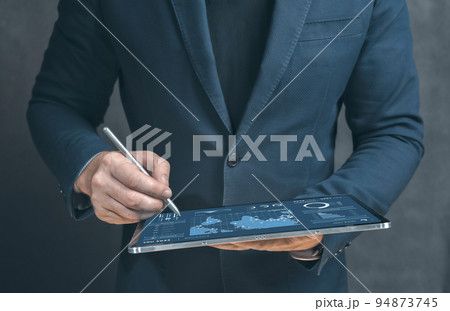 Businessman using tablet analyzing sales data and economic growth graph chart. Business strategy. Tablet and business graphics statistics and analytics. digital transformation 94873745