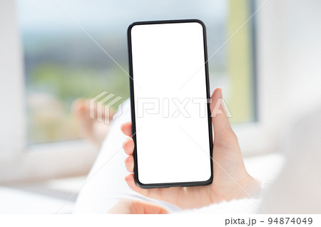 Use mobile shopping app, check social media news, texting mobile sms order food delivery sit near window at home in white clothes 94874049