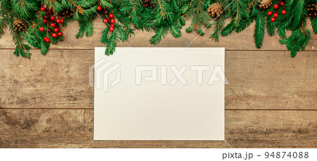 Christmas rustic mockup. sheet of white paper lies on an old table decorated with Christmas fir branches, red berries and cones. wide banner Christmas rustic mockup. sheet of white paper lies on an old table decorated with Christmas fir branches, red berries and cones. wide banner 94874088