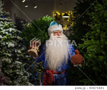 Russian Santa Claus in the store of artificial Christmas trees. Russian Santa Claus in the store of artificial Christmas trees. 94874881