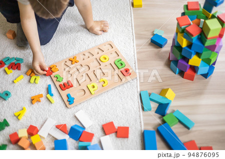 Male kid playing with wooden eco friendly alphabet letters board on table top view intellectual game Male kid playing with wooden eco friendly alphabet letters board on table top view intellectual game 94876095