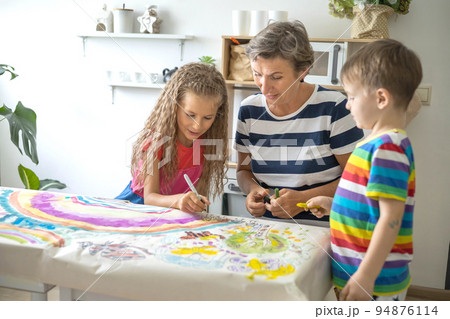 Family mother and kids drawing art picture on paper with multicolored chalks enjoy weekend Family mother and kids drawing art picture on paper with multicolored chalks enjoy weekend 94876114