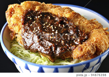 キャベツもたっぷり敷かれている味噌カツ丼を黒背景で撮影 キャベツもたっぷり敷かれている味噌カツ丼を黒背景で撮影 94876398