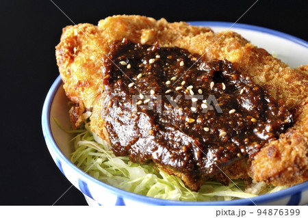 キャベツもたっぷり敷かれている味噌カツ丼を黒背景で撮影 キャベツもたっぷり敷かれている味噌カツ丼を黒背景で撮影 94876399