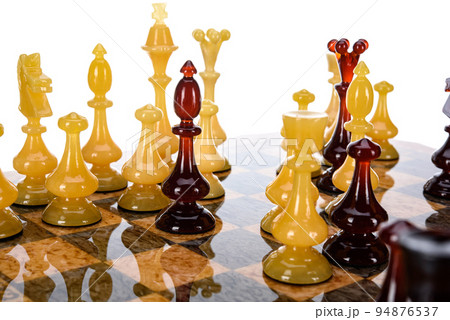 Natural amber different chess pieces figures standing on brown stone board. Close up game concept competition, Classic Gambit Tournament of confrontation. Natural amber different chess pieces figures standing on brown stone board. Close up game concept competition, Classic Gambit Tournament of confrontation. 94876537